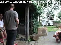 Girls wrestle in car graveyard