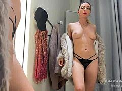 Mira a esta zorrita rubia enseñando sus tetas y culo naturales mientras prueba ropa en el probador del centro comercial público