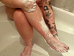Milf seductively washing her feet with big tits on display.