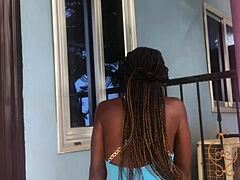 A crazy girl twerks wildly on the outdoor balcony