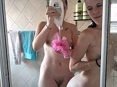 Pale blonde and brunette wash each other in shower