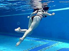 Sheril Blossom, hot Russian teen, strips underwater at beach pool. She shows shaved body in amateur public swim.